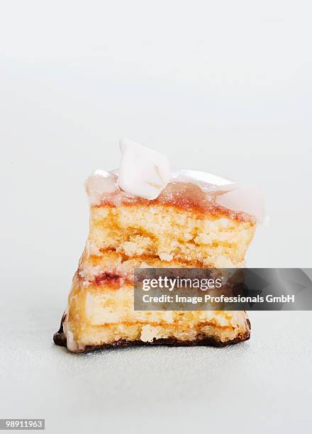 partly eaten petit four with sugar flower, close-up - プチフール ストックフォトと画像