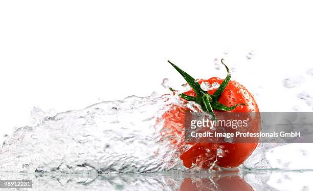 tomato with splashing water, close-up - sepal stock pictures, royalty-free photos & images