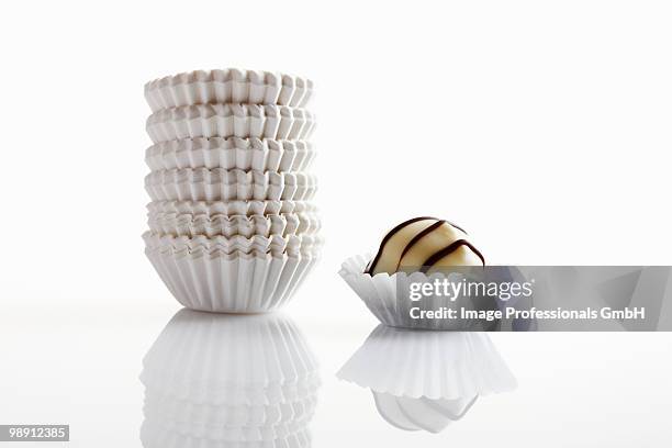 chocolate and stack of paper cases on white background - cupcake holder stock pictures, royalty-free photos & images