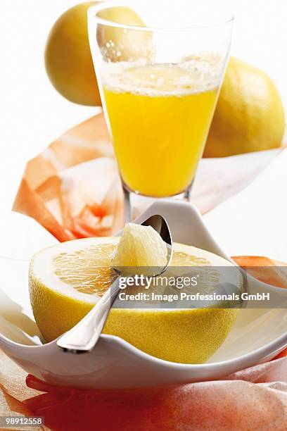 halved grapefruit with spoon and grapefruit juice, close-up - piatto quadrato foto e immagini stock