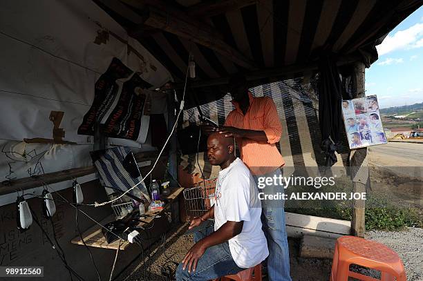 Road side hairdresser shaves the head of a customer in the township of Alexandra in Johannesburg on May 7, 2010. All of the street names in the...