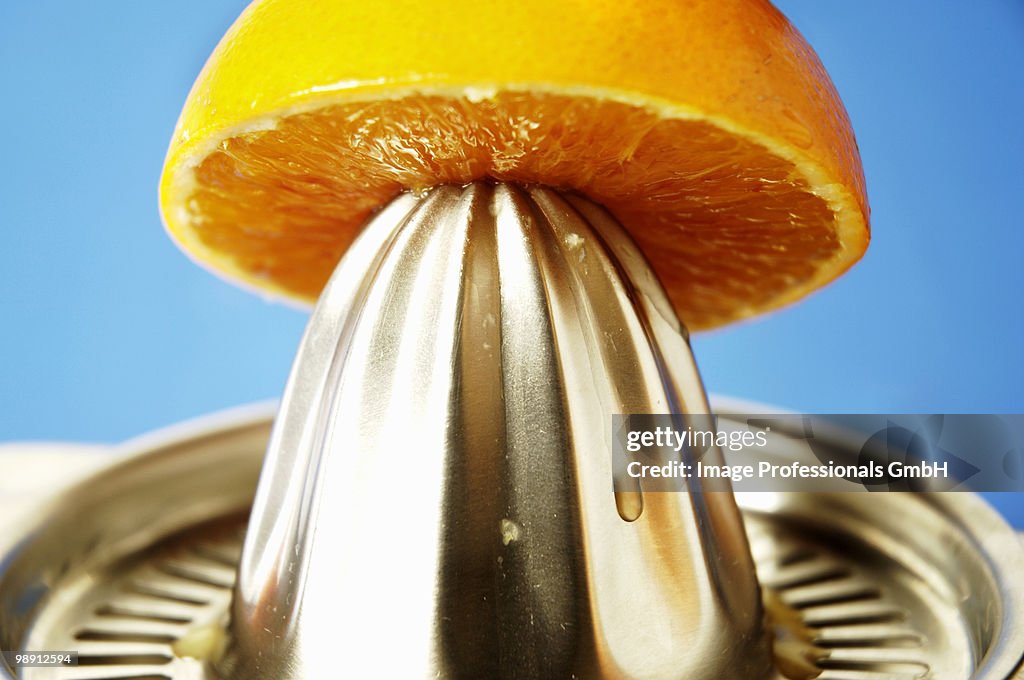 Halved orange on citrus squeezer, close-up