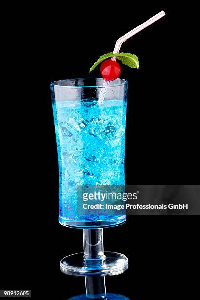 blue curacao with crushed ice in glass on black background, close-up - crushed leaves stock-fotos und bilder