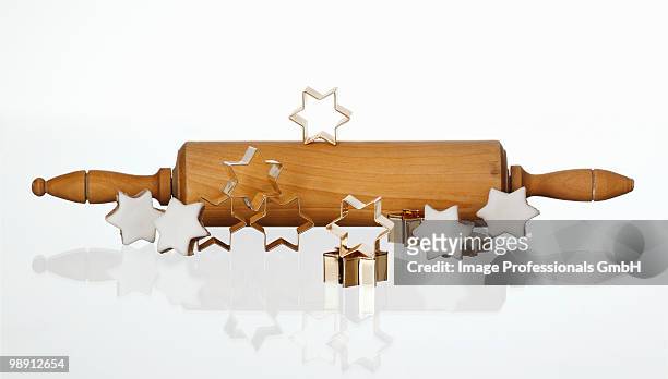 cinnamon stars, cutters and rolling pin on white background, close-up - rolling pin stock-fotos und bilder