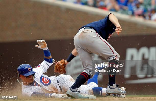 Javier Baez of the Chicago Cubs evades the tag of Brian Dozier of the Minnesota Twins for a double against the Minnesota Twins at Wrigley Field on...