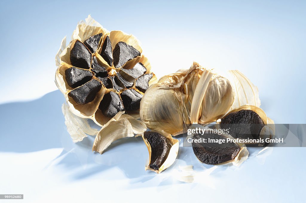 Black garlic on blue background, close-up