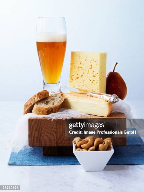cheese, bread, pear and wheat beer on wooden board, close-up - butter knife stock pictures, royalty-free photos & images