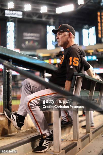 Manager Bruce Bochy of the San Francisco Giants watches from the dugout during the sixth inning of the MLB game against the Arizona Diamondbacks at...