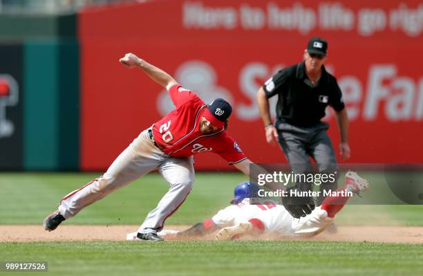 Daniel Murphy of the Washington Nationals reaches for an errant throw as Cesar Hernandez of the Philadelphia Phillies steals second base in the...