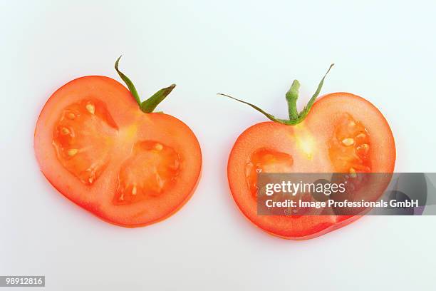 two slices of tomato with calyxes, elevated view, close-up - sepal stock pictures, royalty-free photos & images