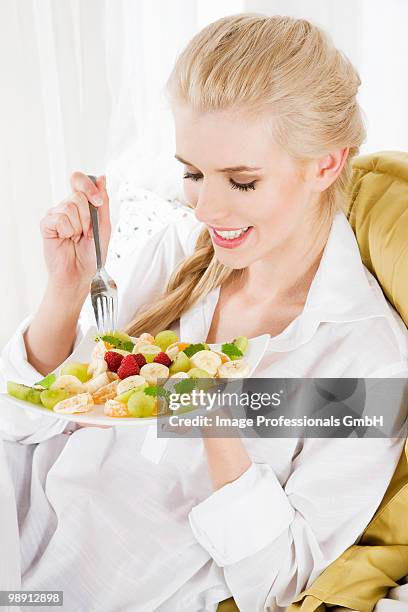 woman eating fruit salad - plato cuadrado fotografías e imágenes de stock