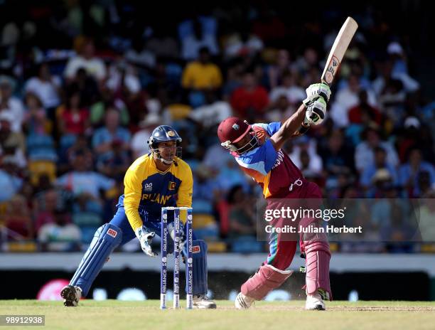 Dwayne Bravo of The West Indies hits out as wicket keeper Kumar Sangakkara looks on during The ICC World Twenty20 Super Eight Match between The West...