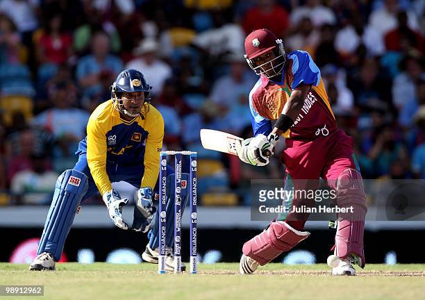 Dwayne Bravo of The West Indies hits out as wicket keeper Kumar Sangakkara looks on during The ICC World Twenty20 Super Eight Match between The West...