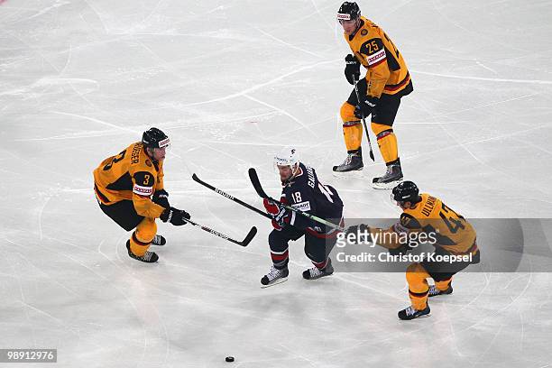 Jason Holland of Germany and Christoph Ullmann challenge T.J. Galiardi of the United States during the IIHF World Championship group D match between...