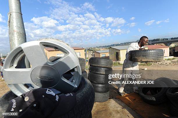 Roadside trye repair man takes his goods from his home to his open air work place in the township of Alexandra in Johannesburg on May 7, 2010. All of...