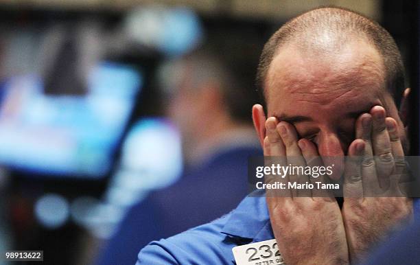 Trader rubs his eyes on the floor of the New York Stock Exchange before the closing bell May 7, 2010 in New York City. Stocks closed down nearly 140...