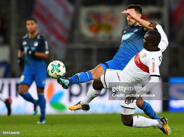 Hoffenheim's Lukas Rupp reaches the ball before Stuttgart's Chadrac Akolo during the German Bundesliga soccer match between 1899 Hoffenheim and VfB...