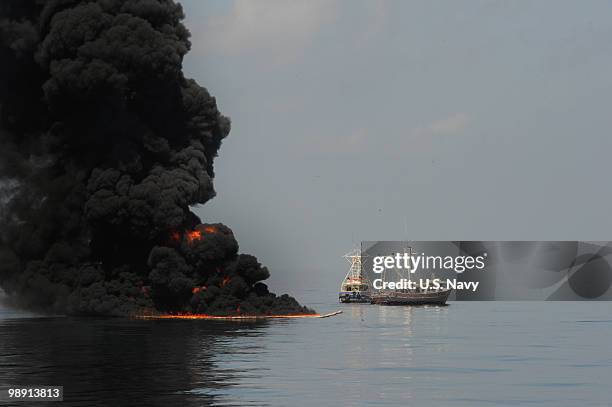 Two fishing vessels drag an oil boom after trapped oil is set ablaze May 6, 2010 in the Gulf of Mexico. The U.S. Coast Guard working in partnership...