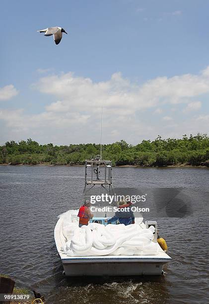 Boat carrying absorbant oil boom heads out towards the Chandeleur Islands May 7, 2010 near Hopedale, Louisiana. Workers continue to try to stop oil...
