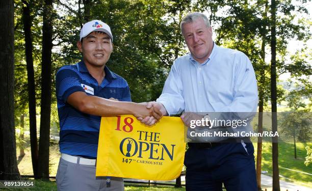 Sung Kang of South Korea is congratulated by John Clark of the R&A Championship Committee after qualifying for the Open Championship during the...