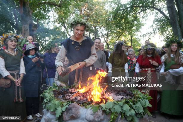 People take part in fire rituals to the Lizdeika altar during the traditional Lithuanian summer solstice in Verkiai Park in Vilnius on June 22, 2018....
