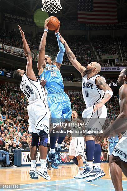 Carmelo Anthony of the Denver Nuggets goes to the basket against C.J. Miles and Carlos Boozer of the Utah Jazz in Game Six of the Western Conference...