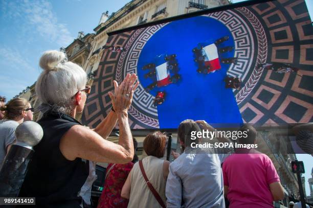 People are seen watching the burial ceremony Simone and Antoine Veil on a huge screen. Burial ceremony at the Pantheon of former French politician...