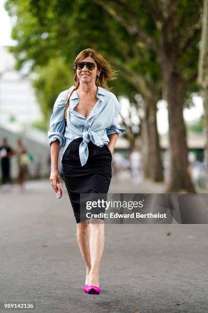 Carine Roitfeld wears a blue shirt, a black skirt, pink shoes, outside Vetements, during Paris Fashion Week Haute Couture Fall Winter 2018/2019, on...