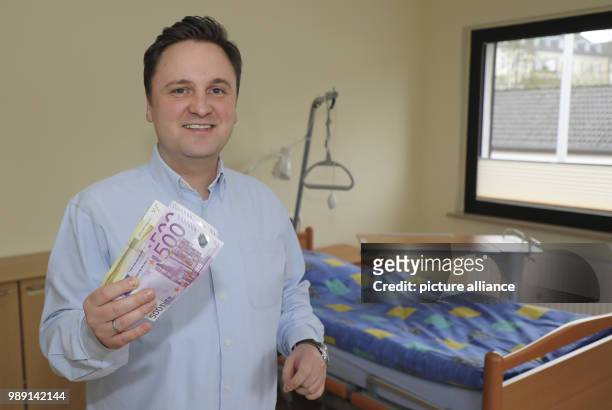 Lucas Weiß, managing director of the hospice Wolfsburg stands inside a guest room holding an anonymous donation, in Wolfsburg, Germany, 14 December...