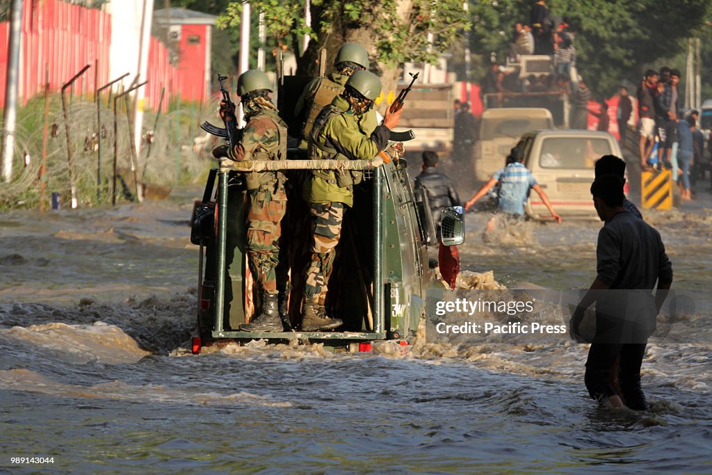 An Indian army vehicle moves through the flooded road in...
