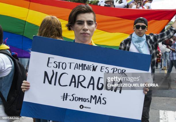 Reveler holds a sign reading "This is also for Nicaragua. We are more" -referring to protests taking place against Nicaraguan President Daniel Ortega...