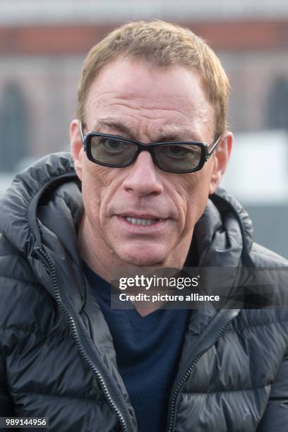Actor Jean-Claude Van Damme wears sunglasses during a press conference in Munich, 14 December 2017. Van Damme is going to play the lead character in...