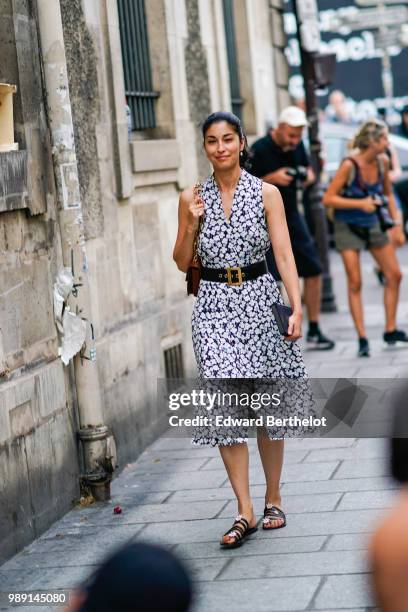 Caroline Issa wears a dress with white floral prints, a belt , outside Givenchy, during Paris Fashion Week Haute Couture Fall Winter 2018/2019, on...