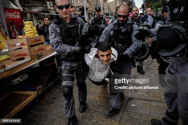 Israeli police officers detain a Palestinian protester during clashes following a protest againt the decision of US-President Trump to recognize...