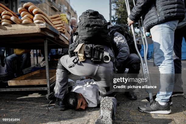 Israeli police officers detain a Palestinian protester during clashes following a protest againt the decision of US-President Trump to recognize...