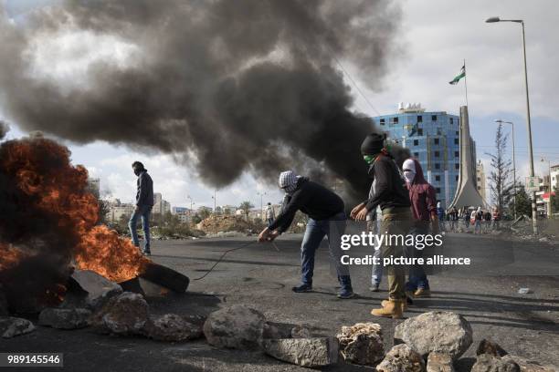 Palestinian protesters burn tyres during clashes with Israeli security forces following a protest against US President Donald Trump's decision to...