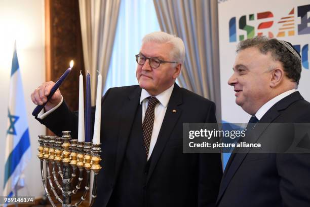 German President Frank-Walter Steinmeier lights the candles in the Hanukkah menorah with Israeli ambassador to Germany Jeremy Issacharoff, at the...