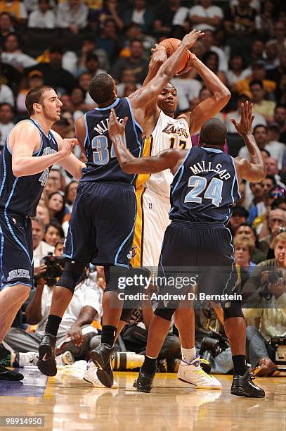 Andrew Bynum of the Los Angeles Lakers moves the ball against C.J. Miles and Paul Millsap of the Utah Jazz in Game One of the Western Conference...