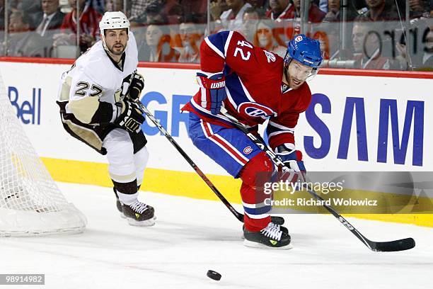 Dominic Moore of the Montreal Canadiens and Craig Adams of the Pittsburgh Penguins watch the rebounding puck in Game Four of the Eastern Conference...