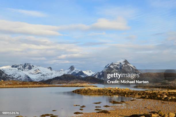 small lake on the mountainous island austvagoey, snowy mountains behind, svolvaer, lofoten, nordland, norway - austvagoy stock pictures, royalty-free photos & images