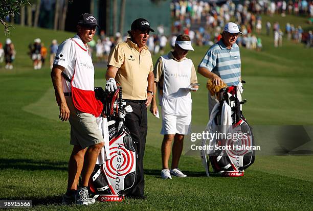 Ernie Els of South Africa waits in the 18th fairway alongside Phil Mickelson and their caddies during the second round of THE PLAYERS Championship...