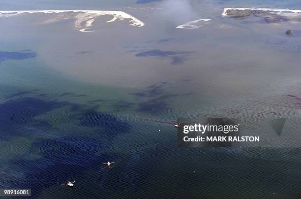 Fishing boats drag oil booms through an oil slick that has passsed inside of the protective barrier formed by the Chandeleur Islands, as cleanup...