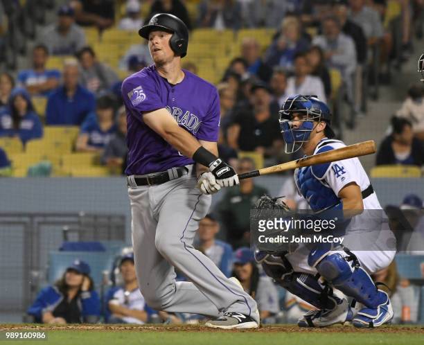 LeMahieu of the Colorado Rockies swings the bat while Austin Barnes of the Los Angeles Dodgers looks on in the seventh inning at Dodger Stadium on...