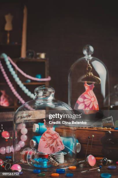 display of miniature dresses and spools of cotton. - thimble stock pictures, royalty-free photos & images