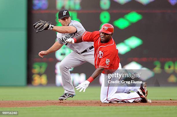 Cristian Guzman of the Washington Nationals slides safely into second base ahead of the tag of Dan Uggla of the Florida Marlins at Nationals Park on...