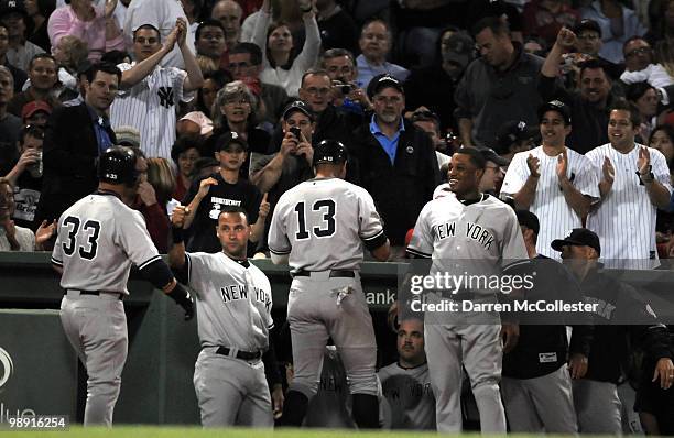 Nick Swisher of the New York Yankees gets congratulated by teammates Derek Jeter, Alex Rodriguez and Robinson Cano following a three run home run...