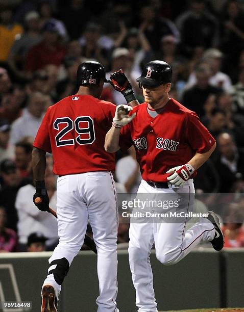 Drew of the Boston Red Sox is congratulated by teammate Adrian Beltre after coming home on a sacrifice fly during the fourth inning against the New...
