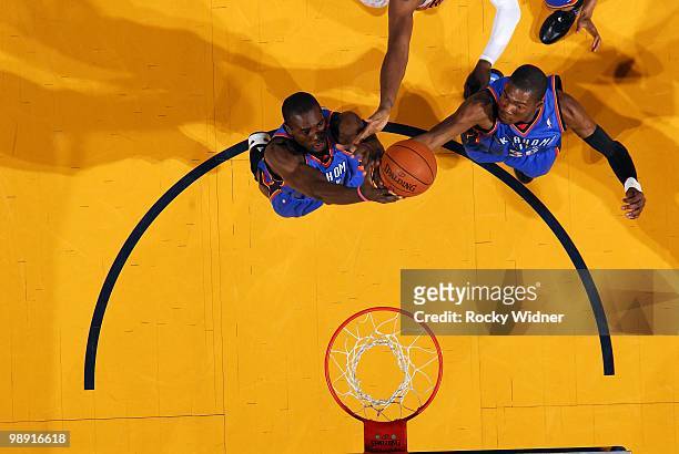 Serge Ibaka and Kevin Durant of the Oklahoma City Thunder team up for a rebound during the game agaist the Golden State Warriors at Oracle Arena on...
