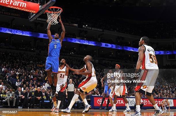 Serge Ibaka of the Oklahoma City Thunder goes up for a shot against Ronny Turiaf and Anthony Tolliver of the Golden State Warriors during the game at...