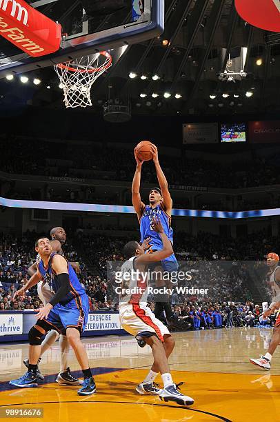 Thabo Sefolosha of the Oklahoma City Thunder goes up for a shot against Reggie Williams of the Golden State Warriors during the game at Oracle Arena...